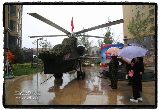 小區(qū)突然出現(xiàn)“飛機(jī)坦克”，其中殲15艦載戰(zhàn)斗機(jī)一架、99式主戰(zhàn)坦克一輛、武直-10武裝直升機(jī)一架，吸引了眾多市民雨中圍觀、合影。